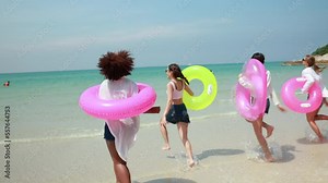 Slow motion Running. Group of teenager girls run on the beach. Four teenager girl female enjoying on inflatable ring on tropical beach. Vacation trip summer holiday. Gen Z