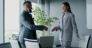 Two business people shaking hands in an office