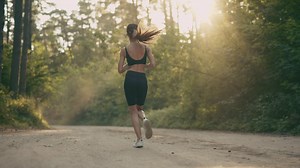 Young woman running thru the forest on a sunny day - Free Stock Video