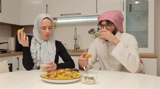 Couple at Table Eating Meal in Home Kitchen