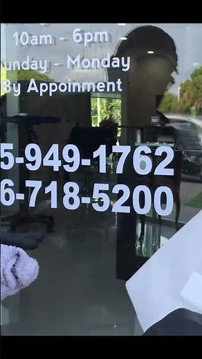 Installing vinyl lettering on the window of a clients storefront door.
