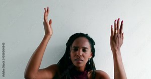 Black woman praying to God, african female raising arms to sky seeking guidance