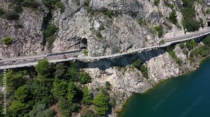 Garda bicycle and pedestrian path suspended above the lake. Alley Limone sul Garda. Section of the longest pedestrian and cycle path in Europe, 4K aerial view. Garda bike path, Italy.