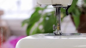 Demonstration of the mechanism of a household sewing machine. How a sewing machine with a lowered leg works, a view at the camera level, a place for copying and text. Concept: atelier, sewing hobby.