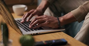Skilled Coder - Close-up shot of the African man's hands swiftly typing lines of code on his laptop, showcasing his expertise as a software developer.
