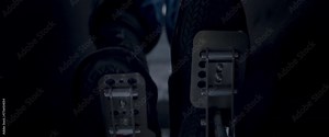Close-up video of a race car drivers legs and feet engaging the pedals