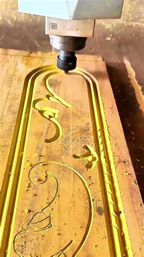 CNC router carving intricate floral wood design.