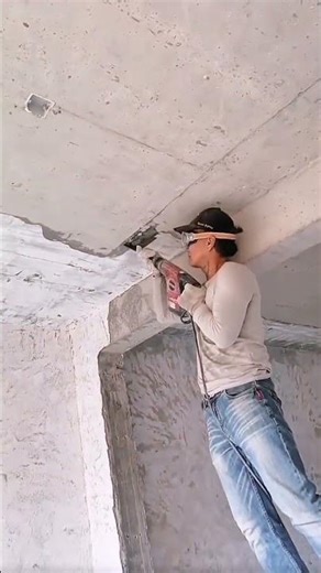 Demolishing a concrete ceiling structure with a heavy duty power tool to prepare for renovations