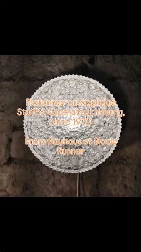 Frédéric Vuillaume on Instagram: "Avec son verre pressé bullé comme un rideau de pluie gelé et son cadre en acier noir mat, cette applique/plafonnier pourrait tout aussi bien éclairer une galerie brutaliste qu’une salle d’attente rétro-futuriste où l'on attend de passer un test de Voight-Kampff. Ce luminaire édité par Staff et fabriqué par Glashütte Limburg incarne le minimalisme architectural allemand des années 1970 : rigueur des lignes, sensualité des matières, et ce mélange rare d’évidence e