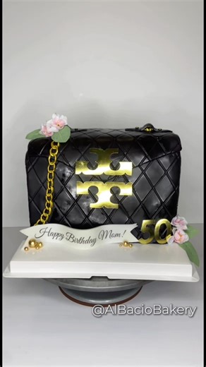Tory Burch Purse Cake 🖤✨ Can You Believe There’s NO Fondant?! 🤯 This Is 100% Handmade Modeling Chocolate Made By Me ✅ Cake Details: Sculpted Cake - 30 Servings Flavor: Classic Vanilla Buttercream: Vanilla Additional: Everything Is Hand Sculpted & Hand Painted. All Additions Are 100% Edible Except The Flowers 🤍 All Cakes, Cupcakes & Treats Come Wrapped In a Luxury Box & Ribbon 🤍 Inquiries? —> Info@AlBacioBakery.com #dallascakes #sculptedcake #cakes #pursecake #cakedecorating
