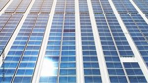From above, a sprawling mosaic of azure solar panels adorns the rooftop, a vibrant testament to eco-conscious innovation, harnessing sunlight for sustainable power. Solar panels background. 4K.