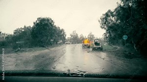Windshield view in heavy rain driving through road construction site