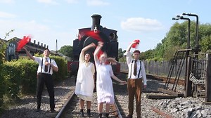 Re-creating the legendary scene where the children stop the train by waving red petticoats. The cast of The Railway Children during the Tethered Wits performance at Didcot Railway Centre on 2 August. | Didcot Railway Centre