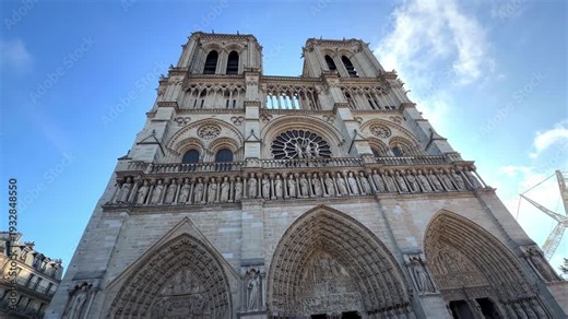 Front view of the Notre-Dame Cathedral west facade with its rose window architecture on a sunny day in Paris, France