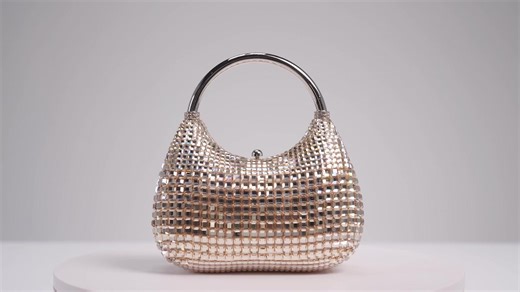 Mesmerizing hues of exquisite champagne disco square crystals intermingle with our timeless smooth crystals to form an alluring gradient pattern on the facade of this deluxe top handle handbag. Brimming with exemplary details and lavish style, this gorgeous piece will bring a breathtakingly opulent touch to your ensemble, no matter the occasion. split Crystal adorned novelty handbag Metallic leather lined interior Push down closure Silver toned metal hardware Removable crossbody chain Judith Lei