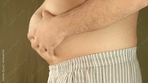 Man Playnig with his fat belly. In Pijamas.