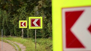 Road signs indicating that a dangerous turn is ahead. Left turn sign: Road signs warn of a sharp turn on a narrow road.