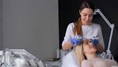 The beautician performs the iontophoresis procedure. Facial skin...