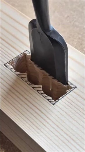 chiseling out a clean rectangular notch in a wood block using a sharp metal chisel for joinery tasks