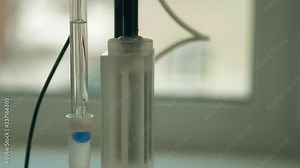 Electrode from pH meter is lowered into the liquid and measures level of acidity. Glass electrode and conductometric cell.