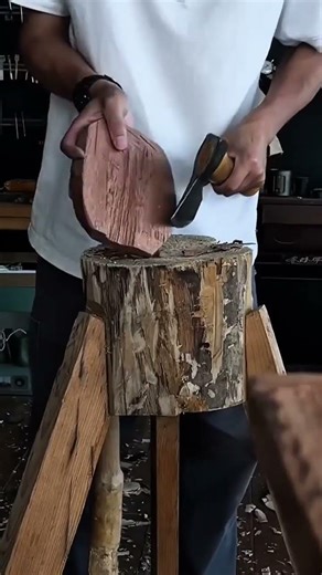 shaping wood with a small axe to create a bowl form using traditional hand tools and craftsmanship