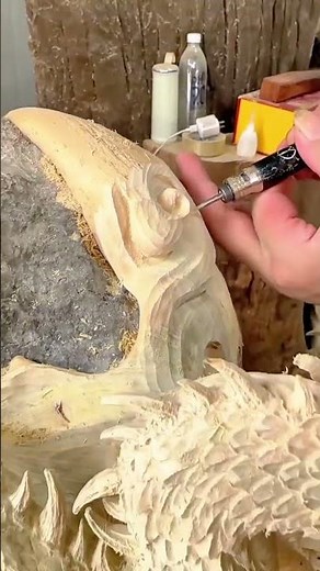 Detailed spiral carving on a wooden sculpture using precision engraving tools