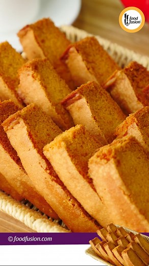 The perfect homemade cake rusk recipe for tea time. Quick, easy and simple cake rusk all in a 2 min well explained recipe video. #HappyCookingToYou Ingredients: -Makhan (Butter) unsalted 100 gms (room temperature) -Cheeni (Sugar) powdered 1 Cup -Anday (Eggs) 3 -Maida (All-purpose flour) 1 Cup -Baking powder 1 tsp -Vanilla essence ¼ tsp -Yellow food color ¼ tsp (optional) Directions: -In bowl,add butter and sugar,whisk well until fluffy. -Add eggs,one by one and whisk well after each addition. -P