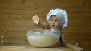 Little baby master chef covered with flour cooking with mother