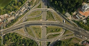 Aerial high drone in 4K flight over evening road traffic in Kiev, Ukraine. Highway and overpass with cars and trucks, interchange, two-level road junction in the big city. Top view.