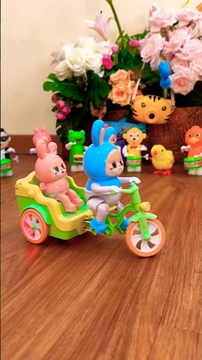 Cute blue and pink rabbit riding a bike