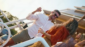 A happy couple dances at a party with friends on a boat