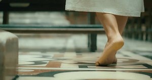 Barefoot pilgrim tramp woman praying in cathedral church. Confession of sins to a priest. Girl came to the priest to repent.