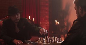 Male friends playing chess game at home