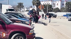 Footage captured by Breitbart Texas on Thursday shows a chain of migrants lined up in Piedras Negras, Mexico, to cross over Texas' border (and the United States') using the Biden administration Custom and Border Protection's One App. | Breitbart
