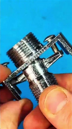 Hand aligns threaded pipe fitting with wall outlet