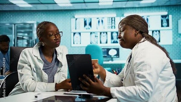 Black specialist providing checkup examination on insurance with patient, employing technology for diagnostic tools in clinic. Girl asking physician about wellness advice, recovery plan. Camera B.