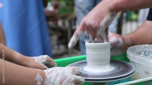 Master of ceramics. We work with clay. The master ceramist teaches the student. Craftsman hands sculpts clay
