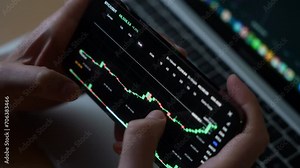 Smartphone with mobile application cryptocurrency wallet. A man analyzes the price chart for bitcoin in a mobile application. The concept of cryptocurrency trading