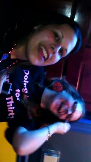 Two girls touch tongue