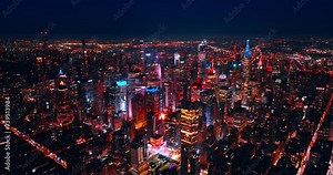 Approaching the midtown of gorgeous New York with amazing skyscrapers lit with neon light. Aerial perspective on the lively metropolis.