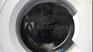 Close-up shot of a washing machine in motion, showcasing spinning laundry through the transparent door, capturing the dynamic energy of modern home appliances.