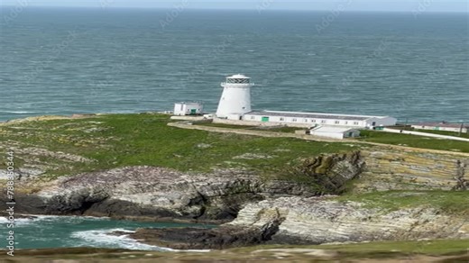 Stunning aerial footage of the historic South Stack Lighthouse, perched on the rugged cliffs of Holy Island, Anglesey, overlooking the Irish Sea.