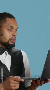 Vertical Video Bellboy doorman talks to guests on videocall connection before booking, explaining all five star resort amenities. Hotel concierge personnel discusses with clients on online conference