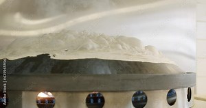Flat bread being cooked or baked on a hot inverted pan.