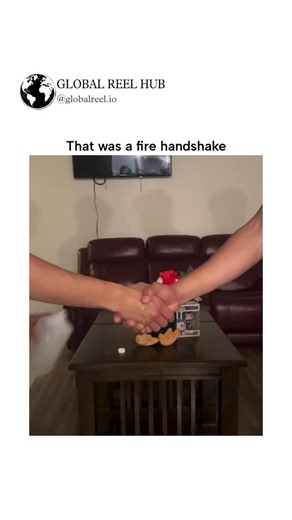 GLOBAL REEL HUB™ on Instagram: "Dm for Credit / Removal The post features a 9-second video of two young men executing an overly dramatic handshake in a living room, starting with a simple grip and escalating to arm twists, prop passes, and a glowing fire effect on their hands, captioned "That was a fire handshake" for comedic effect. Posted by @HumansNoContext , an account specializing in absurd, unfiltered human moments, this clip has garnered over 50,000 views in under a day, with replies prai