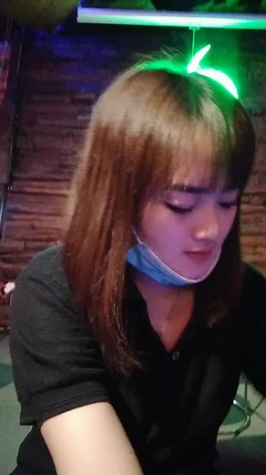 Singing in a Dimly Lit Room with Neon Green Light