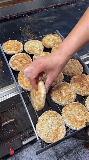 Watch how this traditional baked #Xinjiang cake comes to life on the #street! From kneading the soft dough to spreading that rich sesame paste—every step feels like a warm food tradition 🥮. #foodie | Discover Xinjiang