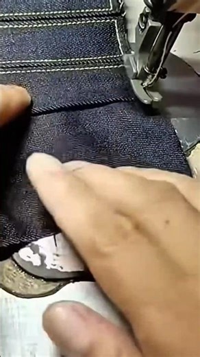 sewing a blue fabric manually using a white metal tool for a very neat building finishing work