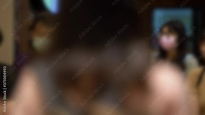 4K, Blurred defocused view of people stand queue with medical masks, long line for eat in a restaurant as store has implemented social distancing measures during the COVID-19 pandemic. Unfocused -Dan