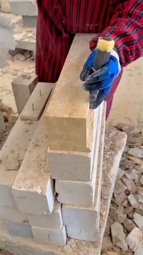 Shaping a sandstone block with hammer and chisel to achieve a smooth and precise edge
